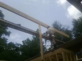 Carpenter setting a ridge beam over a new addition frame — Ice Dam Removal by Roofing Brothers in San Felipe